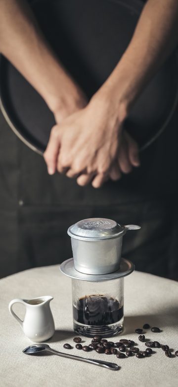 玩美 App 拍摄界面手机截图，屏幕下半部分是滤镜与色温滑块，背景是雨后街道的湿润反光