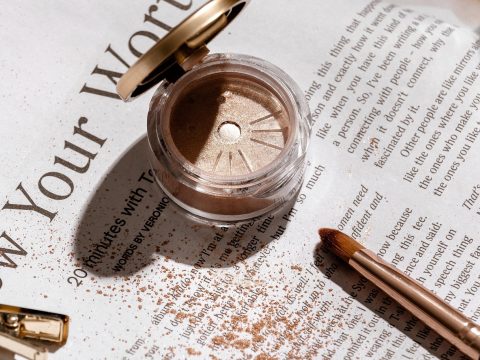 美妆编辑苏禾在自然光下记录试妆效果，手边放着色卡与笔记本，神情专注